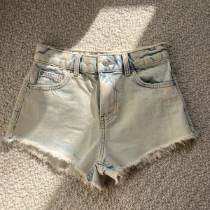 Jeansshorts - Säljer ett par ljusblå helt NYA och OANVÄNDA JEANSSHORTS från Zara med snygg tvättad ”tiedye”effekt, low waisted/ midrise och fransar nertill. Nypris: 350 kr. Pris kan diskuteras. Jättesnygga och perfekta till sommaren!☀️🌊😍