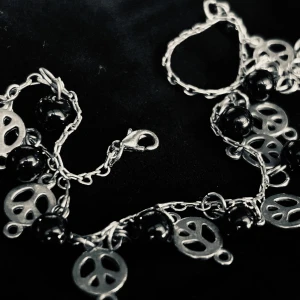 Vinrage-vristlänk med svarta pärlor och peace-symboler! - Vintage-vristlänk med svarta pärlor och peace-symboler från Montini. Längd: 25 cm (+3). Nickelfritt. Mycket fint skick.