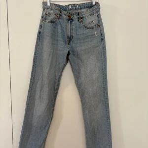 Ljusblå raka jeans från pull and bear  - Klassiska ljusblå lågmidjade jeans med raka ben och femficksmodell. Jeansen har normal passform och knappgylf. Perfekta till vardags för en avslappnad stil.