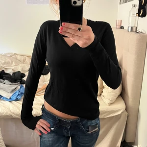 Svart v-ringad tröja från Uniqlo - En klassisk svart v-ringad tröja från Uniqlo. Tröjan har långa ärmar och ribbade muddar vid ärmslut och nederkant. Perfekt basplagg som funkar året runt och är lätt att matcha med andra plagg.