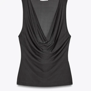 Svart draperad linnetopp - Snygg svart ärmlös topp med djup draperad urringning framtill. Perfekt för att skapa en trendig och stilren look. Tunt och mjukt material som sitter skönt mot kroppen.