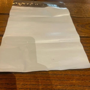 Vit och svart plastpåse - 20 enkel vit plastpåse med svart ovankant. Påsen är rektangulär och har en slät yta. Perfekt för att bära mindre saker eller använda som accessoar till vardagen. Det är 20 st