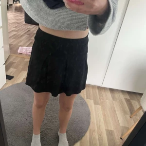 Svart kortkjol från Kappahl - En svart, enkel och stilren kortkjol från Kappahl. Kjolen har en lätt utställd form och bred linning i midjan. Perfekt att matcha med olika toppar för en clean look. Nästan aldrig använd och sitter bra! Priset går att diskuteras!