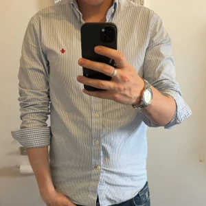 Blårandig skjorta från Morris - Snygg blårandig skjorta från Morris med klassisk krage och rutigt inner tyg som blir riktigt snyggt när man viker upp ärmarna. Aldrig använd 