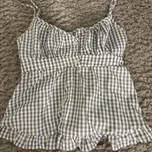 Blårutig linnetopp med volang - Supersöt blårutig linnetopp med smala axelband och volangkant nertill. Super fin och helt ny, storlek xs/s väldigt stretchig så passar m också. 