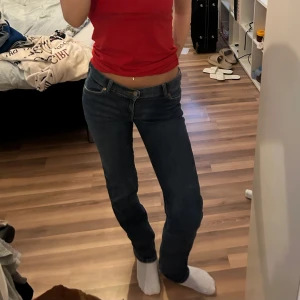 Mörkblå jeansbyxor med normal passform - Säljer ett par klassiska mörkblå jeansbyxor med normal passform och midwaist. Byxorna har fem fickor och stängs med dragkedja och knapp. Perfekta till vardags och enkla att matcha med olika toppar. Nypris 450kr på rea säljpris: 235