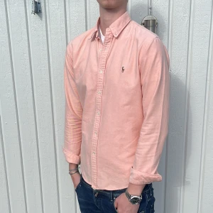 Rosa Ralph Lauren Skjorta - Tja! Säljer nu denna galet feta Ralph Lauren Skjortan! Toppskick utan några defekter, 9/10! Färgen är Ljusrosa/Aprikos, riktigt fet till sommaren!☀️Storlek M Slim Fit, Fits= S/M! Äldre modell, därav lite högre kvalité! Hör av dig vid minsta fråga eller fundering!🌟