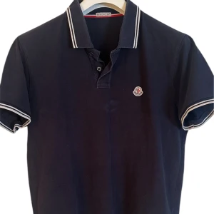 Moncler  - Moncler Polo. Storlek Xl passar även L. Skick 8.5/10 fin. Pris 890kr finns att köpa på våran hemsida. Fashionels.com