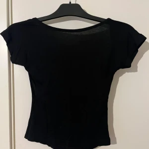 Svart croppad topp men öppen rygg - En enkel svart croppad topp med korta ärmar och öppen rygg. Perfekt till sommaren🩷 den är i stl XXS, han använt ca 5 ggr. Från shein