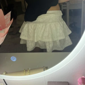 Vit volangkjol med spetsdetaljer - Supersöt vit kjol med dubbla volanger och spetsmönster. 