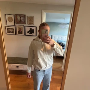 Vit hoodie med ficka framtill - Säljer en enkel och stilren vit hoodie med luva. Tröjan har en stor magficka och är långärmad. Perfekt för en avslappnad look. Skriv gärna om fler bilder! Säljer då den är för liten