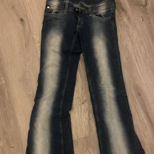 Lågmidjade jeans - Säljer ett par blå Lågmidjade bootcut jeans från weekday. Använda ca 2 gånger!