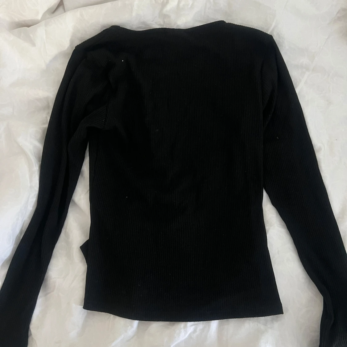 Svart ribbad topp med sned knäppning - 1