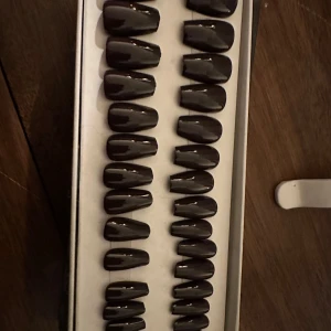 Switch nails - Säljer ett set med mörkbruna lösnaglar i färgen 'Espresso Yourself'. Naglarna har en ballerinaform och kommer i flera storlekar. Fil och träpinne medföljer.