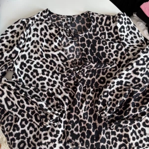 Leopardmönstrad blus med knytning - Säljer en snygg leopardmönstrad blus med långa ärmar och knytning framtill, o med resår vid ärmsluten! Väldigt skönt material 🖤🤎