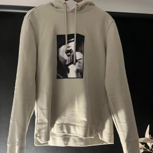 Beige hoodie med tryck från Limitato x Ellen von Unwerth - Säljer en beige hoodie från Limitato i samarbete med Ellen von Unwerth. Tröjan har ett svartvitt konstnärligt tryck framtill, huva med snören. 