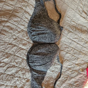 Svart och vit mönstrad bikini-bh från Freya - Säljer en bikini-bh från Freya med svart och vitt prickigt mönster. Bh:n har bygel och breda axelband för extra stöd. Perfekt för strand eller poolhäng! Storlek 75H enligt EU-mått. Ny pris 750 kr . Säljer för 450