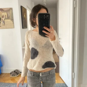 Beige stickad tröja med svarta prickar - Säljer en beige stickad tröja med svarta prickar. Tröjan har lång ärm och en avslappnad passform. 