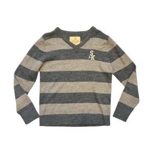 Randig stickad tröja - Säljer en stickad tröja med breda grå och beige ränder. Tröjan har v-ringning och långa ärmar, samt en broderad SK-logga på bröstet.