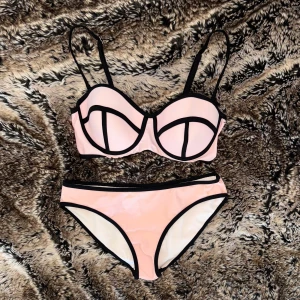 Ljusrosa bikini med svarta kanter - Säljer en ljusrosa bikini med svarta kontrastkanter och bygel-bh med justerbara axelband. Bikinin har en modern och stilren design, perfekt för stranden eller poolen! ⊹ obs: axelbanden är avtagbara men jag har sytt fast dem så de inte lossnar när man badar eller likande, det går dock att klippa bort detta (tråden), om man vill ha avtagbara axelband igen! ⊹ jag är 173cm & stl S/36/28 för referens ⊹ läs POLICY (i gillade inlägg) innan köp ⊹ använd gärna ”Köp” ⊹ 