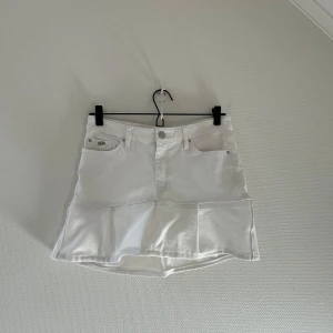 Vit jeanskjol med volang - Snygg vit jeanskjol med volangdetalj. 