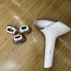 Philips Lumea IPL hårborttagningsapparat med tre munstycken - Säljer en Philips Lumea IPL hårborttagningsapparat i roséguld och vitt.  Har använts ca 3 gånger men ska flytta så behöver göra mig av med den. Medföljer tre olika munstycken för kropp, ansikte och bikinilinje. Enkel att använda med digital display och flera effektlägen. Perfekt för smidig hårborttagning hemma. 7000 kr i butik. 