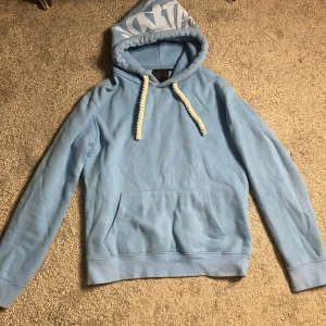 Syna wrld hoodie ljusblå - Lite sliten med någon fläck hör o där men borde gå bort i tvätten säljer då den blivit för liten. Storlek S. Kan mötas upp eller frakta 