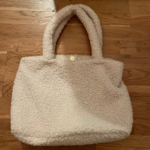 Fluffig väska  - Säljer en vit fluffig väska. Jag själv har använt den typ 1 gång men jag köpte den från sellpy. Den har en fläck inut i. (Tar tyvärr inga returer) 