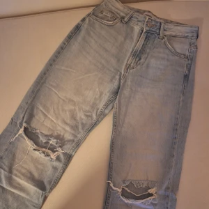 Ljusblå slitna jeans  - Ljusblå jeans med slit baggy