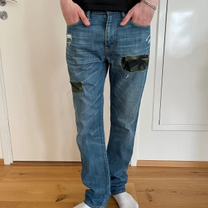 Camouflage Levi’s jeans 32/32 - Nu säljer vi ett par sjukt feta och designrika Levi’s jeans med camouflage patches. Skick 9/10. Storlek: 32/32. Modell: 511. Pris 399kr. Designade av RetroRejeans 