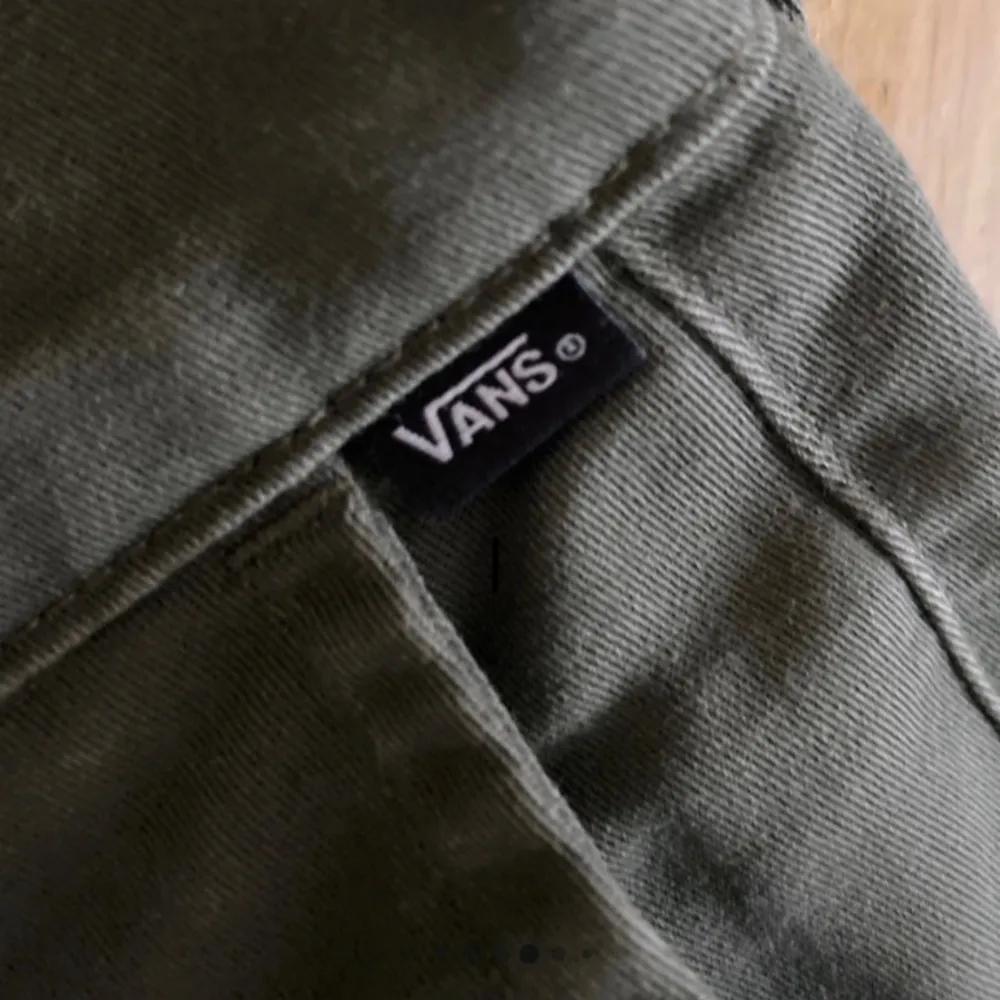 Säljer ett par olivgröna chinos från Vans, modell Authentic Chino. Byxorna har slim fit-passform och klassisk design med knapp och dragkedja framtill. Perfekta för dig som gillar stilrena och bekväma byxor.. Farkut & Housut.