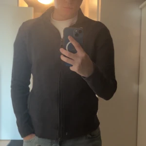 grå zip up från Massimo Dutti - Säljer en stilren grå zip up  från Massimo Dutti i extrafin bomull. tröjan har dragkedja och långa ärmar, perfekt för en avslappnad look. 