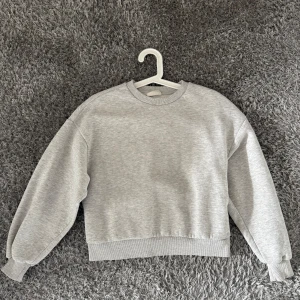 Grå sweatshirt  - Säljer en stilren grå sweatshirt. Tröjan har en klassisk rund hals och långa ärmar med ribbade muddar. Perfekt för en avslappnad look. 🩶