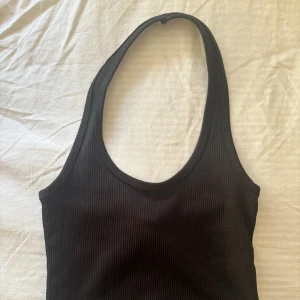 Ribbad topp - Snygg svart ribbad halterneck topp från H&M. Enkel och stilren design som går att matcha med. Skriv vid frågor ☺️