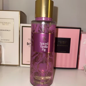 Spiced Vanilla Fig Body Mist från Victoria's Secret - En lyxig body mist från Victoria's Secret i doften Spiced Vanilla Fig. Flaskan är lila med guldiga detaljer och har ett elegant blommönster. Rymmer 250 ml och har en praktisk sprayfunktion. Perfekt för dig som älskar varma, kryddiga och söta doftnoter.