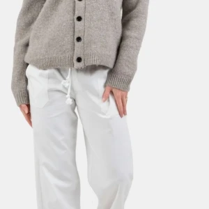 Vita linnebyxor  - Säljer ett par vita linnebyxor med bred resår i midjan och snörning med tofsar. Byxorna har raka ben och sidfickor, perfekta för en avslappnad stil.