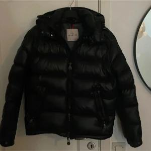 Svart Moncler Maya jacka  - Säljer en svart Moncler Maya,Perfekt för kalla dagar och riktigt snygg, jag har haft den 1 vinter så den är i riktigt bra skick! Skicka pm för fler bilder osv!