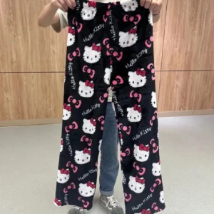 Hello Kitty mjukisbyxor svart rosa - Supermysiga svarta mjukisbyxor med Hello Kitty-motiv och rosa rosetter över hela byxorna. Byxorna är vida och har resår i midjan, perfekta för chill dagar hemma. Materialet är mjukt och fluffigt för extra komfort.