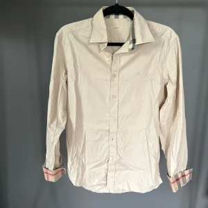 Burberry skjorta - Riktigt snygg burberry skjorta, beige. Bra skick utan märkvärdiga defekter, storlek M