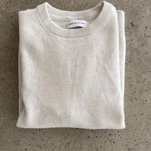 Ljusgrå merinoulltröja These Glory Days - Snygg och stilren ljusgrå tröja från These Glory Days i mjuk och exklusiv merinoull. Klassisk rund halsringning och långa ärmar, perfekt för lager-på-lager. Enkel design som funkar till allt och känns riktigt fräsch.
