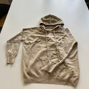  Kashmir  hoodie  - Den här tröjan e perfekt för sommaren. Med dens mjuka material, och den beiga färgen sitter den perfekt på nån med storlek XS