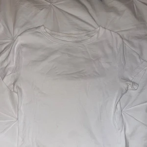 Vit ribbad t-shirt  - En basic vit ribbad t-shirt från New Yorker Modellen är kortärmad med rund halsringning och har en tight passform. 