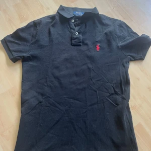Svart pikétröja Polo Ralph Lauren - En skön piké från Ralph Lauren. Det är ett mycket bra skick på pikén inga defekter eller liknande. Jag köpte den på Ralph Laurens egna butik på hede fashion outlet så den är äkta! Den passar dig som är ungefär 165cm. Om ni har några frågor eller funderingar är det bara att kontakta mig!👌