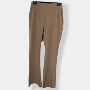 Beiga kostymbyxor från H&M, strl 40 - Snygga beiga kostymbyxor från H&M i storlek 40. Byxorna har dold dragkedja i sidan för en clean look. Perfekta till en stilren outfit och lätta att matcha med olika toppar.