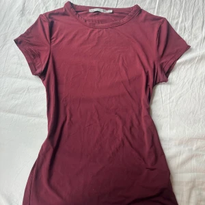 Vinröd t shirt  - Säljer min vinröda t shirt från lager 157. Har väldigt mjukt och stretchigt material och sitter tajt. Säljer pågrund av att den inte kommer till användning längre