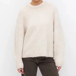 Beige stickad tröja med rund hals - Enkel och snygg beige stickad tröja med rund halsringning och långa ärmar. Tröjan har en loose passform och ribbade muddar vid ärmslut och nederkant. Perfekt för lager-på-lager och chill dagar.