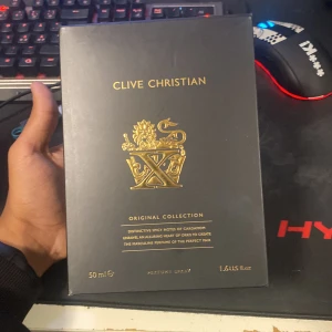 Clive Christian X Original Collection 50ml - Lyxig parfym från Clive Christian, Original Collection X. Flaskan är svart med gulddetaljer och en ikonisk kronformad kork. Kommer i elegant svart och guldig presentask. Doften har kryddiga toner av kardemumma och iris. Perfekt för dig som gillar exklusiva och unika parfymer.