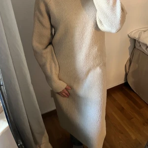 Stickad långklänning - Mysig beige stickad långklänning med polokrage och långa ärmar. Supervarm och perfekt inför hösten/vintern. Använd fåtal gånger 💕💕