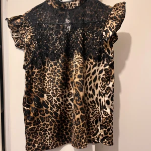 Blus strl S/M - Kortärmad topp i strl S/M från Jubylee. Leopard mönstrad med spets. 
