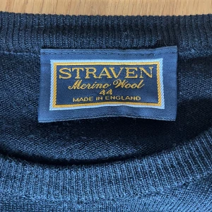 Mörkblå merinoullströja från Straven - Klassisk mörkblå tröja från Straven i 100% merinoull. Enkel och stilren design med rund halsringning och långa ärmar. Perfekt för dig som gillar en clean look och vill ha något mjukt och skönt att bära under kyligare dagar. Har ett hål i armen